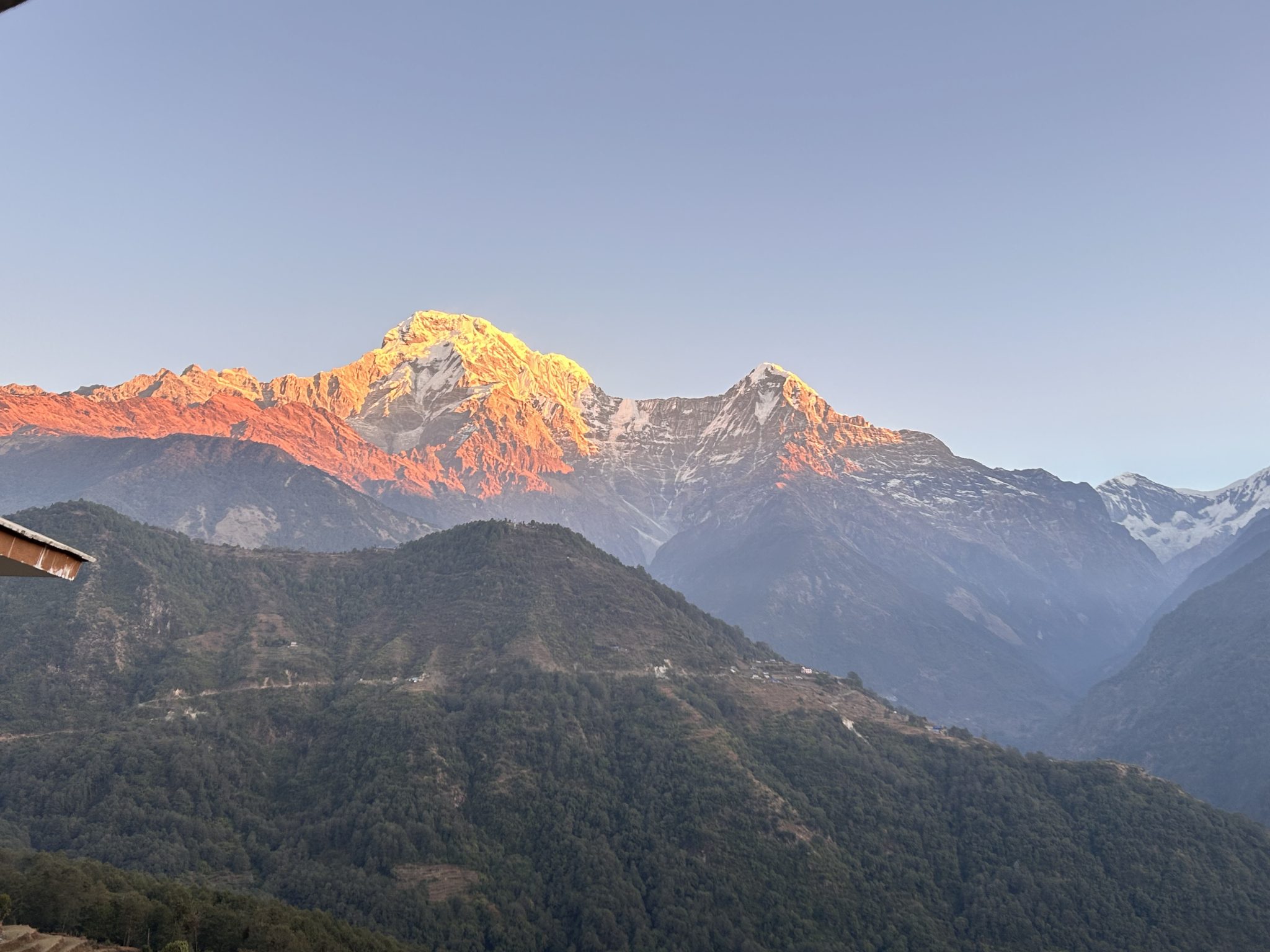 Early morning hues illuminate the snowy himalayas, casting a golden glow in this captivating view!
